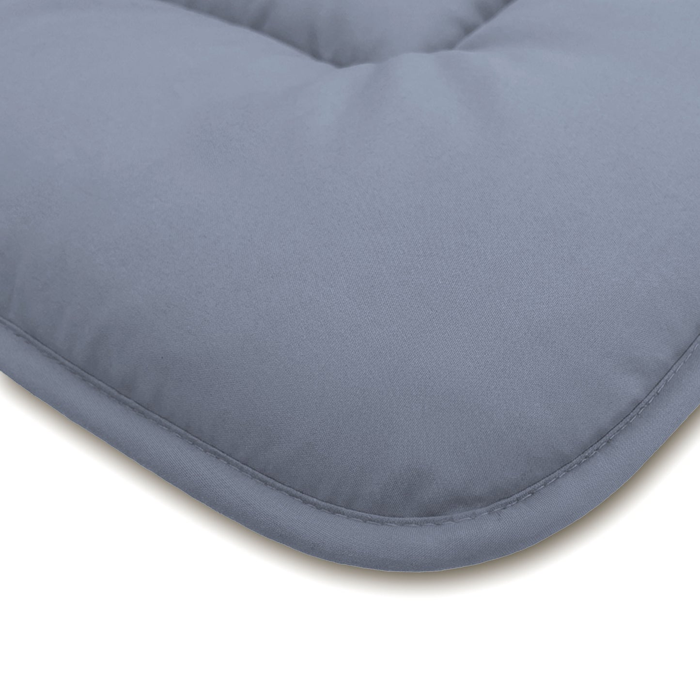 Nahaufnahme einer hellgrauen gepolsterten Oberfläche mit abgerundeten Kanten und sichtbaren Randnähten, die an die Zelesta Comfort Duo Bettdecke in Eisblau & Sanftes Blau erinnert.
