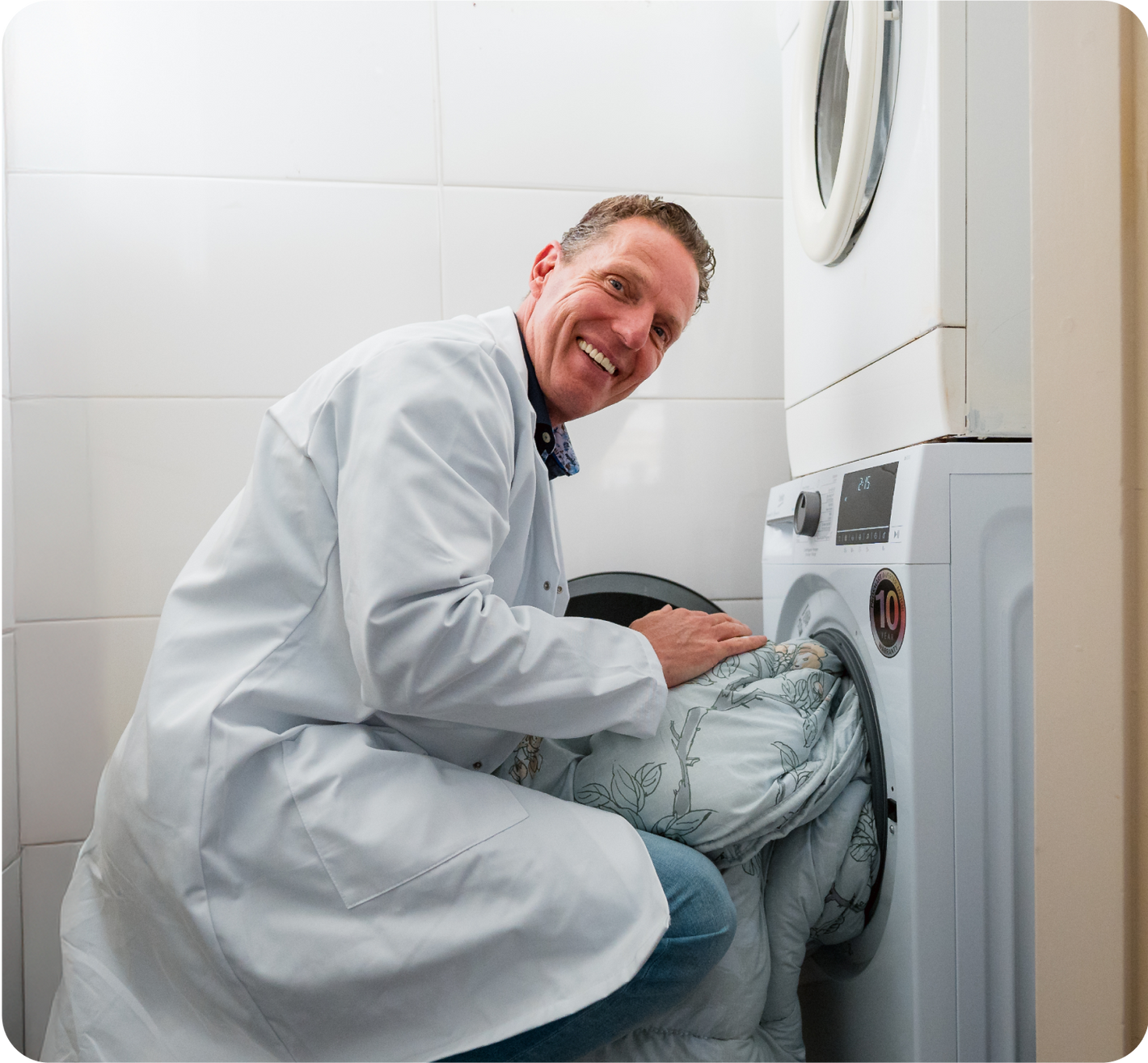 Hygieneexperte Rob Geus steckt die Bettdecke in die Waschmaschine.