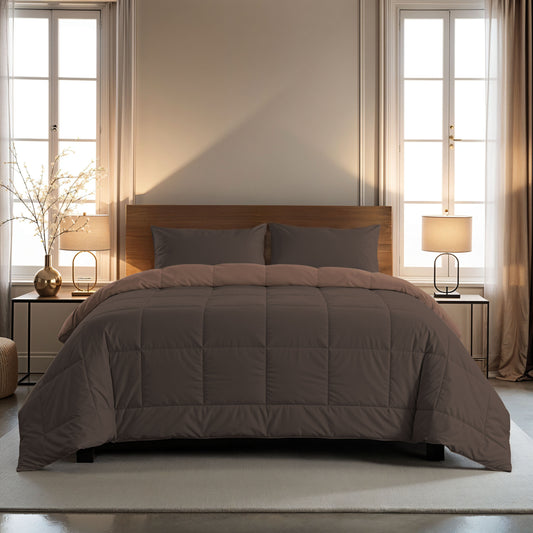 Ein ordentlich gemachtes Bett mit einer braunen Mikrofaser-Bettdecke und einem 80x80cm Zelesta Comfort Duo Kissenbezug in Schokoladenbraun, flankiert von zwei Nachttischen mit Lampen, vor großen Fenstern mit beigen Vorhängen.