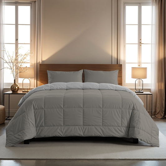 Ein ordentlich gemachtes Bett mit einer grauen Bettdecke und zwei 80x80cm Zelesta Comfort Duo Kissenbezug - Grau zwischen Fenstern, Nachttischen und Lampen in einem sanft beleuchteten Schlafzimmer.