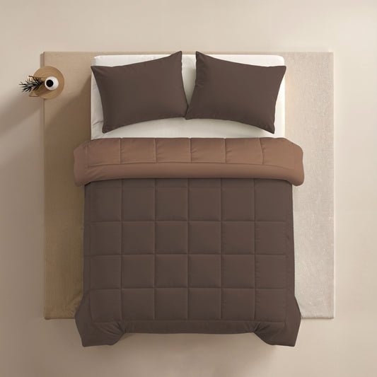 Ein ordentlich gemachtes Bett mit Zelesta Comfort Duo Kissenbezug - Schokoladenbraun (80x80cm) und Bettdecke, ein hellbraunes Laken und eine runde dekorative Vase auf dem Nachttisch, von oben gesehen.