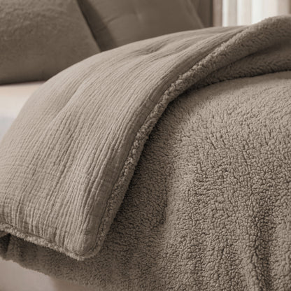 Nahaufnahme des Zelesta Teddy Baumwolle Musselin - Taupe Bettwäschesets, das die strukturierte Musselin-Baumwolldecke und die weiche Teddy-Sherpa-Decke auf einem Bett zeigt.