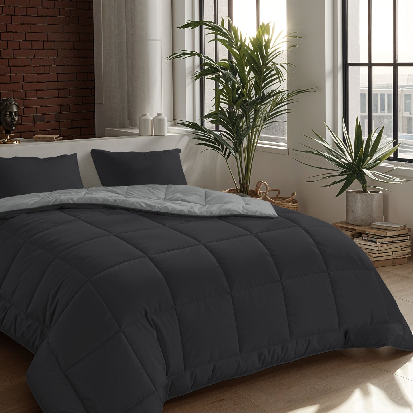 Ein ordentlich gemachtes Bett mit einer Zelesta Comfort Duo Bettdecke in Sanftes Schwarz & Silbergrau ziert ein modernes Schlafzimmer mit großen Fenstern, Zimmerpflanzen und auf dem Boden gestapelten Büchern.