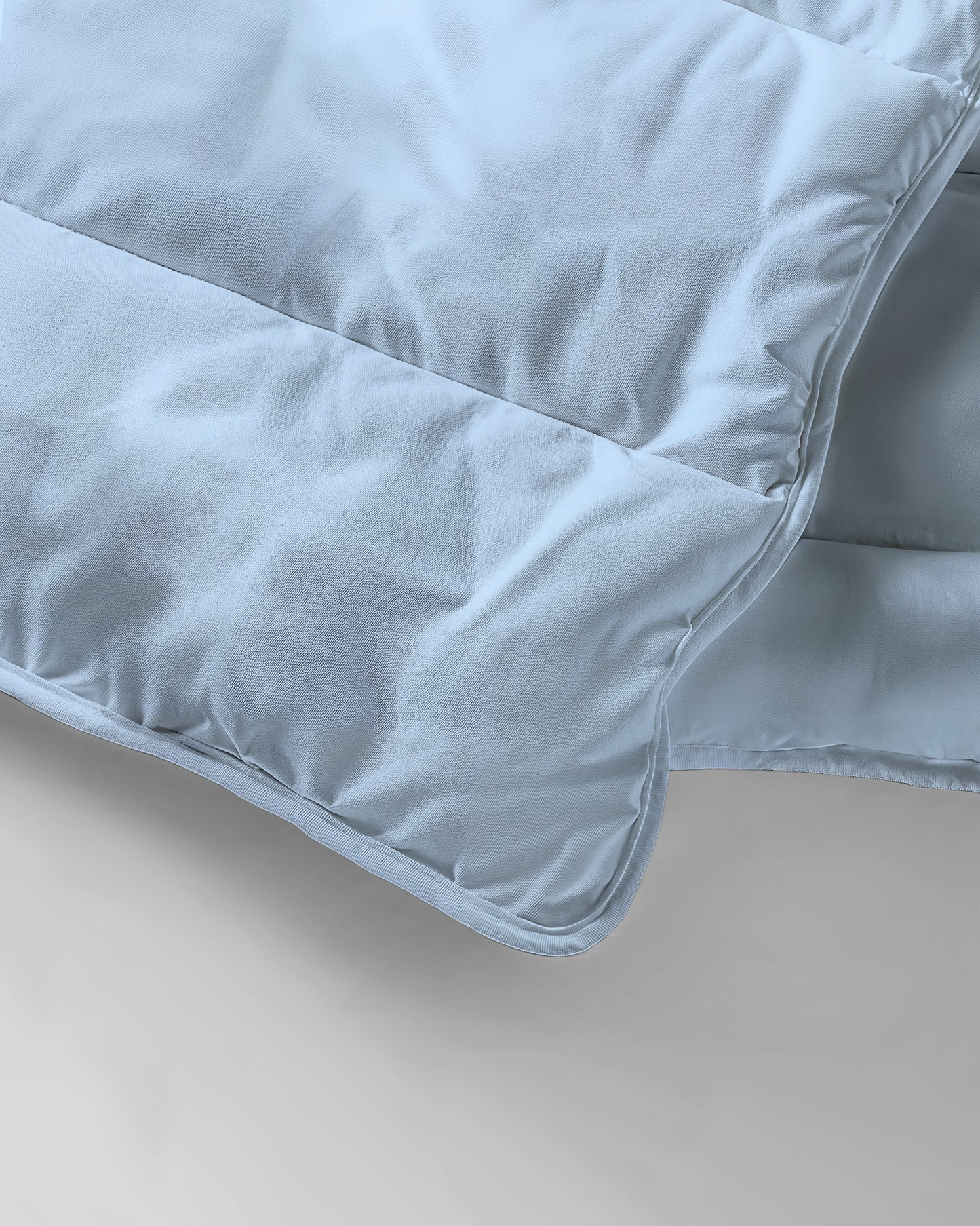 Nahaufnahme der Zelesta Everyday Uni Bettdecke - Hellblau, die durch ihre weiche Stoffstruktur, die Steppung und die präzisen Steppdetails besticht.