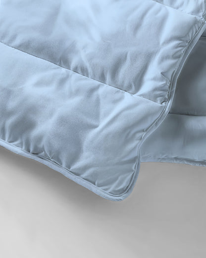 Nahaufnahme der Zelesta Everyday Uni Bettdecke - Hellblau, die durch ihre weiche Stoffstruktur, die Steppung und die präzisen Steppdetails besticht.