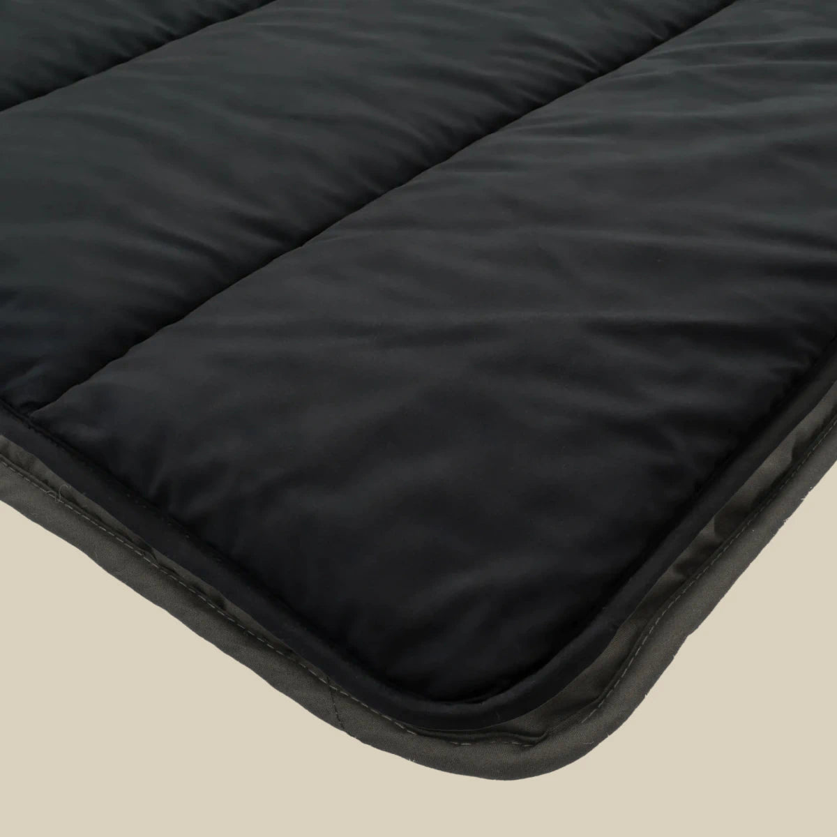 Nahaufnahme der schwarzen Zelesta Comfort Uni Bettdecke mit Steppnähten, dargestellt auf einem hellen Untergrund.