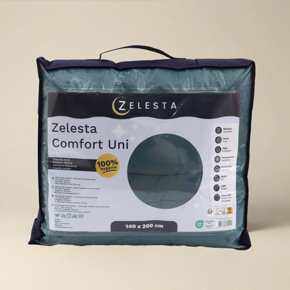 Eine verpackte Zelesta Comfort Uni Bettdecke - Seegrün aus der Komfort-Linie, in einer transparenten Tragetasche mit Produktetikett, Größe 140 x 200 cm. Perfekt als All Season Bettdecke oder für diejenigen, die eine Bettdecke mit festem Bezug wünschen.
