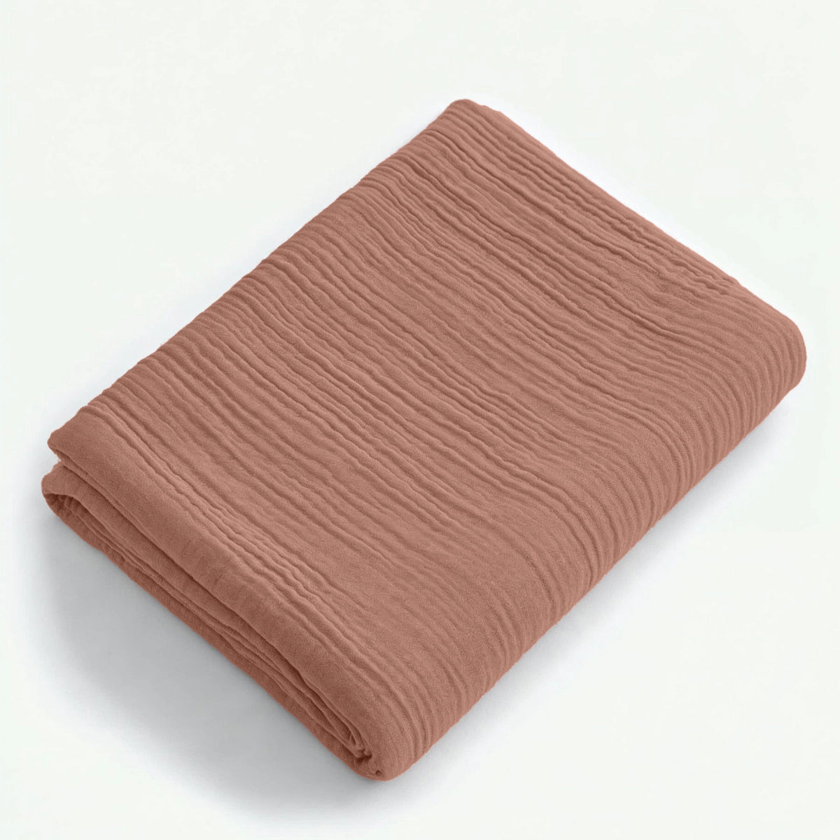 Ein gefaltetes, strukturiertes Musselin-Spannbettlaken in Dusty-Rose ist auf weißem Hintergrund abgebildet.