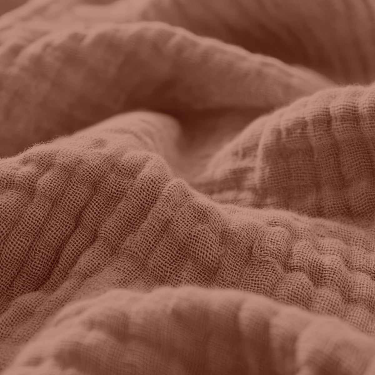 Nahaufnahme des Musselin Spannbettlaken - Dusty-Rose, mit weichem, strukturiertem Stoff aus hochwertiger Baumwolle mit sichtbaren Falten und Knicken.