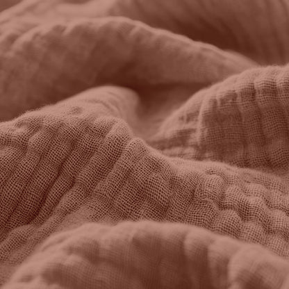 Nahaufnahme des Musselin Spannbettlaken - Dusty-Rose, mit weichem, strukturiertem Stoff aus hochwertiger Baumwolle mit sichtbaren Falten und Knicken.