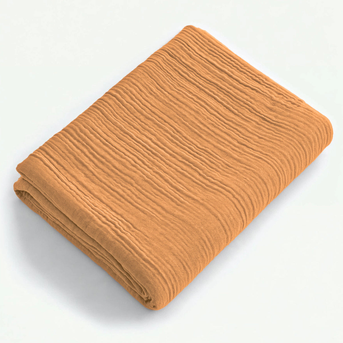 Ein gefaltetes Musselin Spannbettlaken - Taupe mit einer strukturierten Oberfläche wird auf einem schlichten weißen Hintergrund dargestellt.