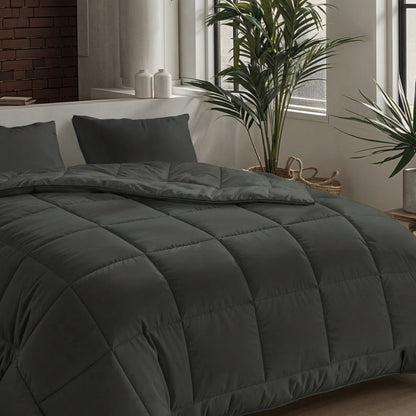 Ein ordentlich gemachtes Bett mit der Zelesta Pure Uni Bettdecke in olivschwarz und passenden Kissen an einem Fenster mit Grünpflanzen und natürlichem Licht bietet erstklassigen Slaapkomfort, der an duurzame dekbedden erinnert.