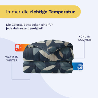 Eine gefaltete gemusterte Bettdecke, das Royalbed Baumwolle - Dark Leaves, wird mit Symbolen für Wärme im Winter und Kühle im Sommer gezeigt. Der Text hebt die Ganzjahrestauglichkeit hervor und dass sie allergikergeeignet ist.